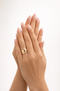 Kadın elinde takılı VIP geometrik altın yüzük, minimal ve lüks stüdyo fotoğrafı.