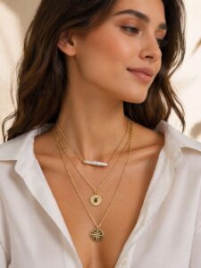 Katmanlı altın kolye seti; üstte barok inci detaylı kısa kolye, ortada nazar boncuklu yuvarlak kolye ve altta yıldız motifli uzun kolye, model üzerinde zarif görünüm.